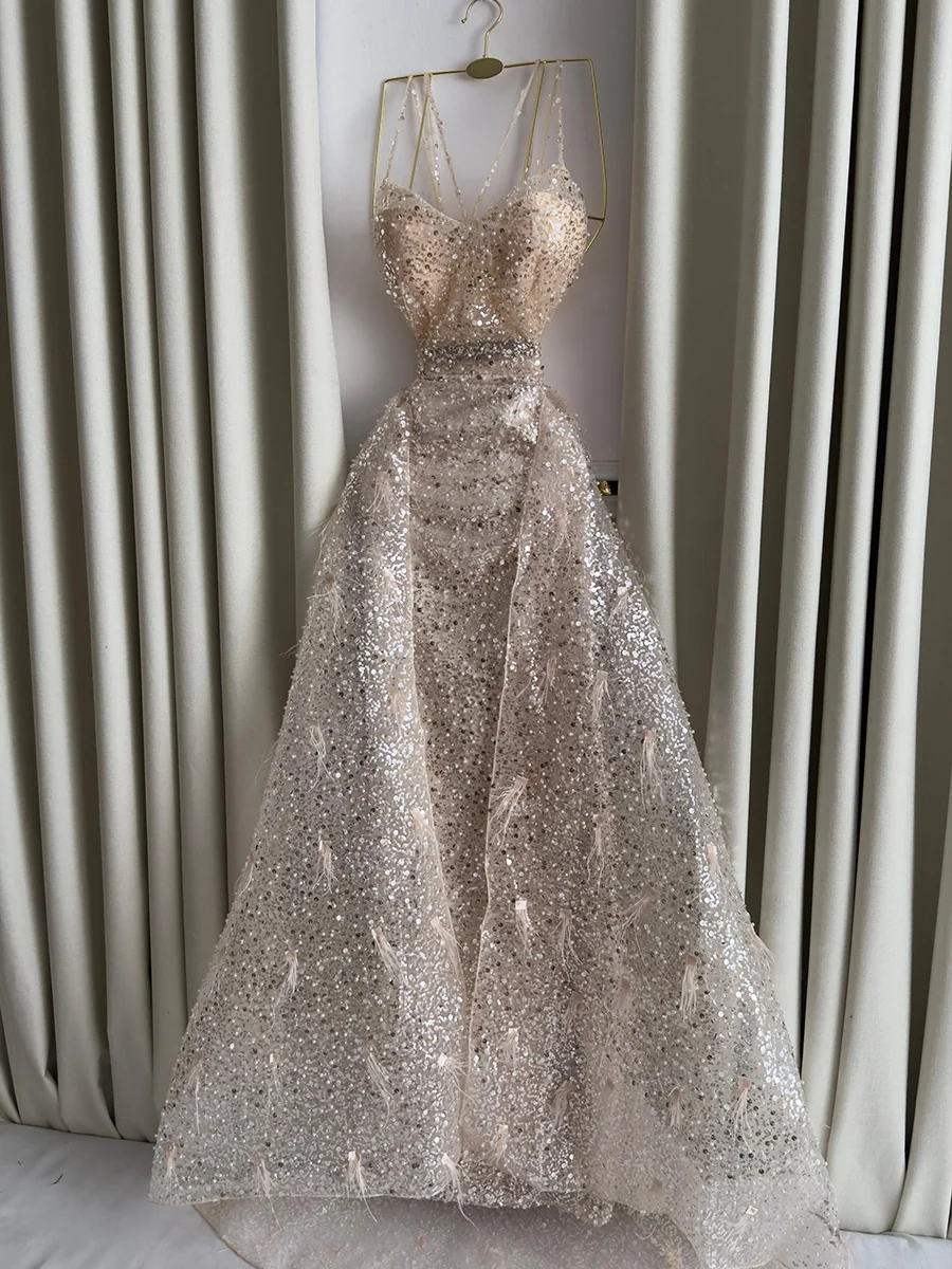 فستان سهرة ذهبي مطرز بالترتر والريش الفاخر